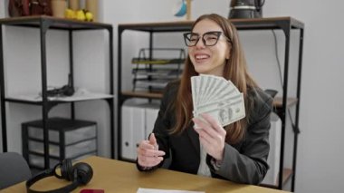 Genç İspanyol iş kadını ofise dolar atıyor.