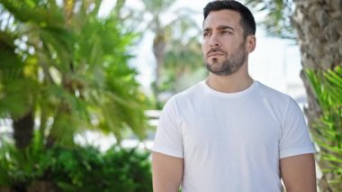 Parkta ciddi bir ifadeyle duran İspanyol genç adam.