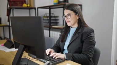 Ofisteki not defterine not alan genç İspanyol iş kadını.