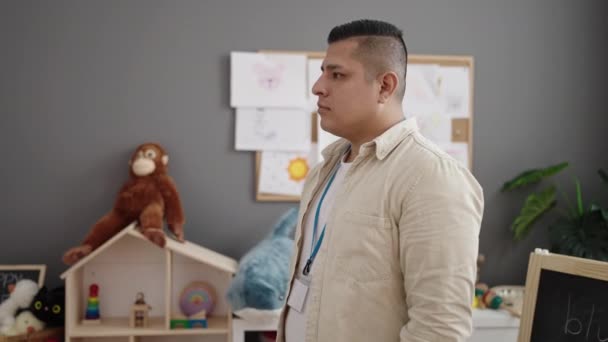 Young Hispanic Man Preschool Teacher Smiling Confident Standing Kindergarten — Stockvideo