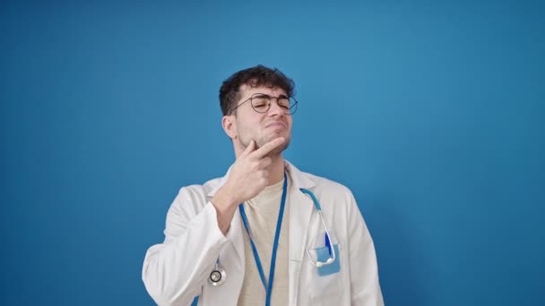 Joven Médico Hispano Pie Con Expresión Duda Pensando Fondo Azul — Vídeos de Stock