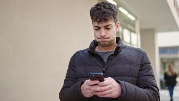 Jeune Homme Hispanique Utilisant Smartphone Regardant Loin Rue — Video