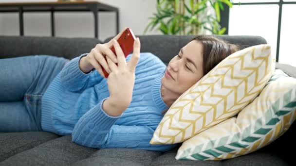 Mujer Joven Caucásica Usando Teléfono Inteligente Tumbado Sofá Casa — Vídeos de Stock