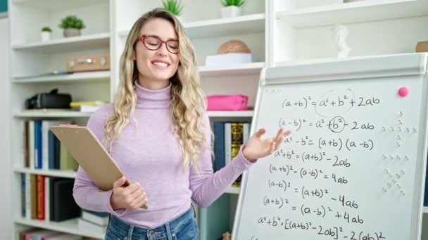 Junge Blonde Frau Lehrerin Unterrichtet Mathematik Unterricht Mit Klemmbrett Klassenzimmer — Stockvideo