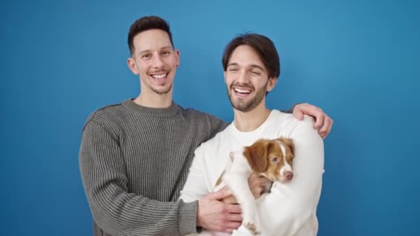 Due Uomini Coppia Baci Piedi Abbraccio Cane Isolato Sfondo Blu — Video Stock