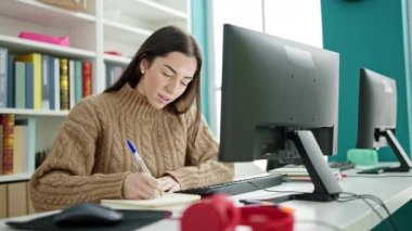 Üniversite sınıfında bilgisayar kullanan güzel İspanyol bir kız öğrenci.