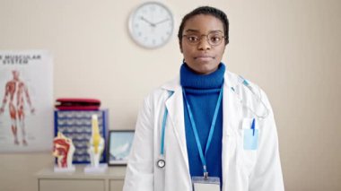 Afro-Amerikalı kadın doktor klinikte başparmağını kaldırıyor.