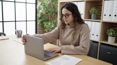 Young beautiful hispanic woman business worker using laptop working at office
