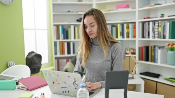 若い白人女性学生は図書館大学でノートパソコンを使うことを強調した — ストック動画