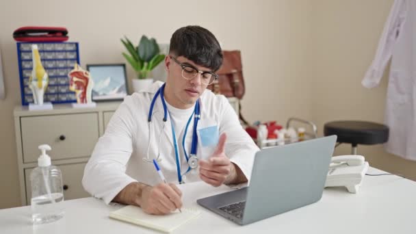 Young Hispanic Man Doctor Doing Video Call Stressed Clinic — ストック動画