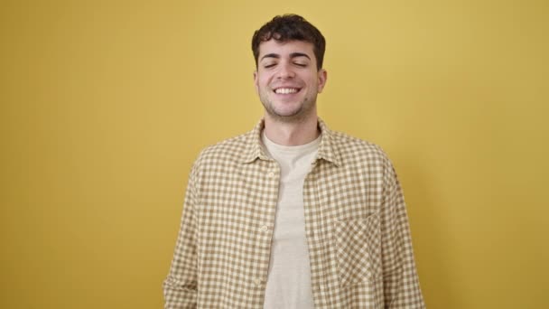 Jonge Spaanse Man Glimlachend Met Duim Omhoog Geïsoleerde Gele Achtergrond — Stockvideo