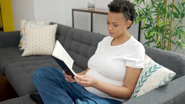 Young Pregnant Woman Reading Book Sitting Sofa Home — Video