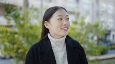 Young chinese woman smiling confident looking to the side at park