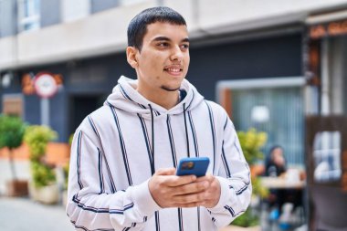 Sokakta akıllı telefon kullanan kendine güvenen genç adam.