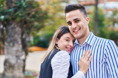 Man and woman couple smiling confident hugging each other at park