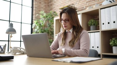 Young beautiful hispanic woman business worker using laptop working at office