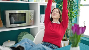 Genç İspanyol kadın gülümsüyor. Yemek odasında rahatlıyor.