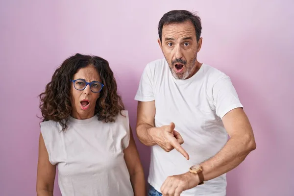 Middelbare Leeftijd Hispanic Paar Samen Roze Achtergrond Haast Wijzend Naar — Stockfoto