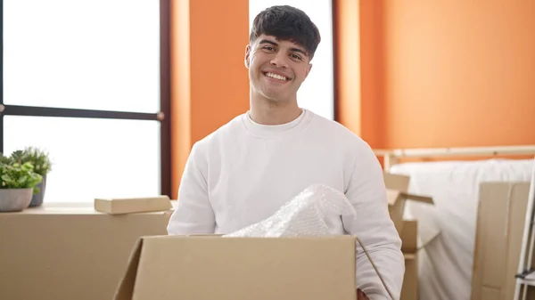 Молодий Іспаномовний Чоловік Посміхається Впевнено Тримає Пакет Новому Будинку — стокове фото