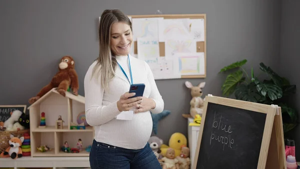 Mladá Těhotná Žena Předškolní Učitel Úsměvem Sebevědomě Pomocí Smartphone Školce — Stock fotografie
