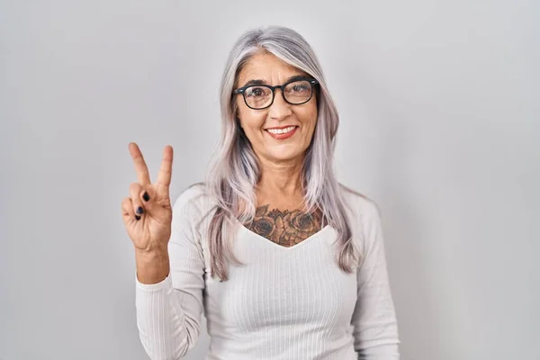 Женщина Средних Лет Седыми Волосами Стоящими Белом Фоне Показывающими Пальцами — стоковое фото