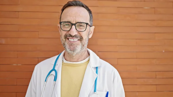 Médico Hombre Mediana Edad Sonriendo Confiado Pie Sobre Fondo Ladrillo — Foto de Stock