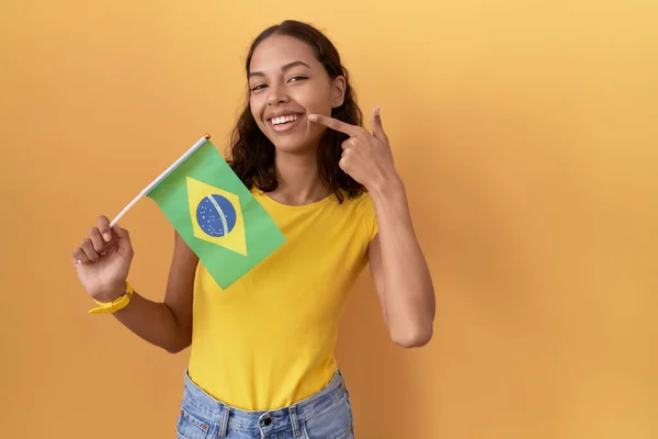 Молодая Латиноамериканка Бразильским Флагом Весело Улыбающаяся Показывающая Пальцами Зубы Рот — стоковое фото