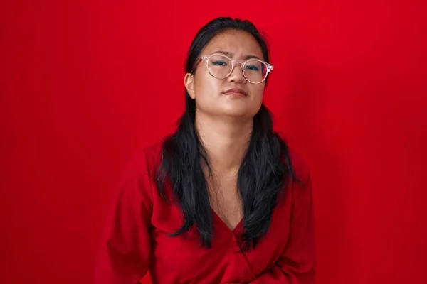 Asiatisk Ung Kvinna Står Över Röd Bakgrund Med Handen Magen — Stockfoto