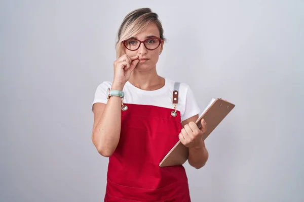 Młoda Blondynka Mundurze Kelnera Trzymająca Podręczną Buzię Usta Zamknięte Jak — Zdjęcie stockowe