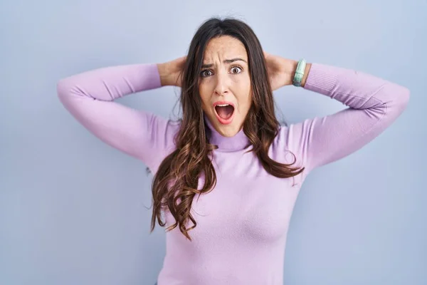Young Brunette Woman Standing Blue Background Crazy Scared Hands Head — Stock Photo, Image