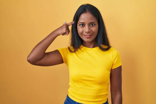 Sarı Arka Planda Duran Genç Hintli Kadın Gülümseyerek Tek Parmağıyla — Stok fotoğraf