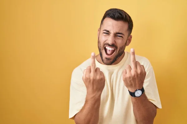 Handsome Hispanic Man Standing Yellow Background Showing Middle Finger Doing — стоковое фото