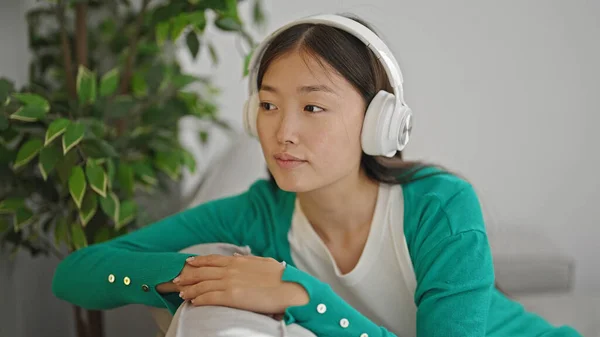Young Chinese Woman Listening Music Sitting Sofa Home — Stockfoto