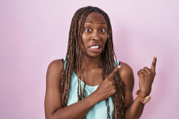 Африканская Американка Стоящая Розовом Фоне Указывая Сторону Обеспокоенный Нервный Обеими — стоковое фото