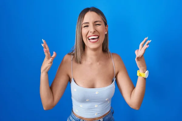 Young Woman Standing Blue Background Celebrating Mad Crazy Success Arms — Stock Photo, Image
