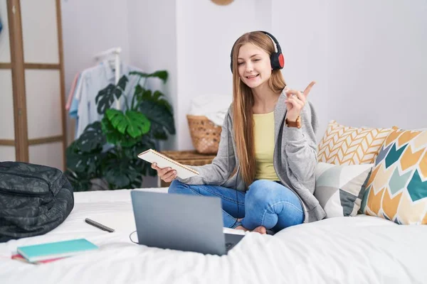 Mladá Běloška Studuje Laptopem Sedícím Posteli Šťastně Usmívajíc Ukazujíc Rukou — Stock fotografie