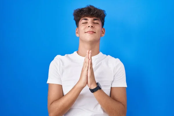 Ισπανόφωνος Έφηβος Στέκεται Πάνω Από Μπλε Φόντο Επαιτεία Και Προσεύχεται — Φωτογραφία Αρχείου