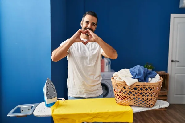 Sakallı Sakallı Evde Ütü Yapan Aşkla Gülümseyen Elleriyle Kalp Sembolü — Stok fotoğraf