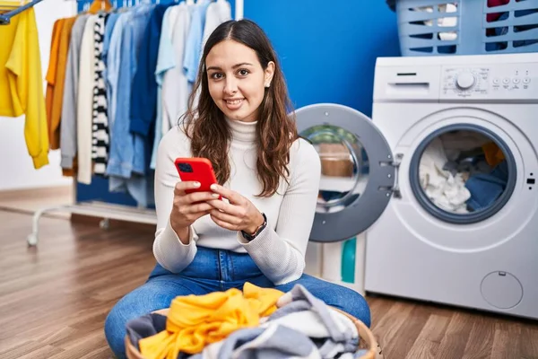 Young Beautiful Hispanic Woman Smiling Confident Using Smartphone Laundry Room — ストック写真