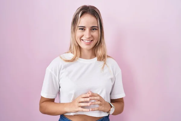 Young Blonde Woman Standing Pink Background Hands Together Fingers Crossed — Stockfoto