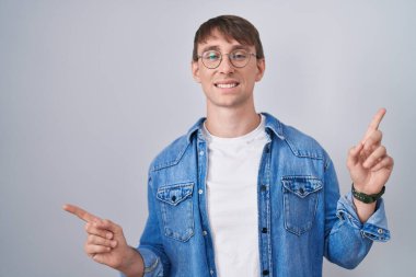 Beyaz, sarışın, gözlüklü, kendine güvenen, farklı yönleri gösteren bir adam. reklam için kopyalama alanı 