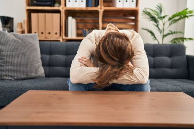 Young caucasian man patient stressed sitting on sofa at psychology clinic