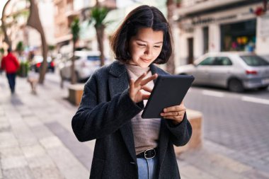 Sokakta dokunmatik ped kullanan kendine güvenen genç bir kadın.