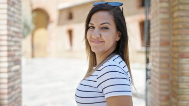 Orta Doğulu bir kadın sokakta kendinden emin gülümsüyor