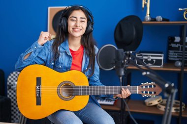 Genç kız müzik stüdyosunda klasik gitar çalıyor. Gururla bağırıyor, zaferi ve başarıyı kutluyor. 