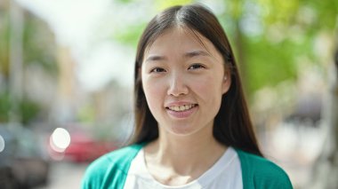 Young chinese woman smiling confident standing at street