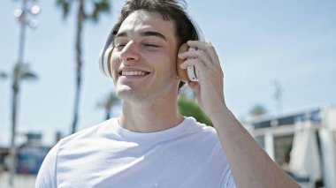 Sokak ortasında dans edip müzik dinleyen genç bir İspanyol.