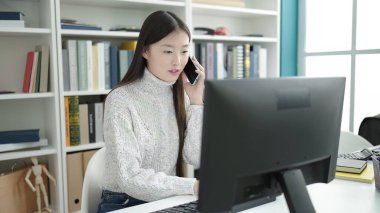 Kütüphane üniversitesinde bilgisayar kullanan Çinli genç bir kız öğrenci.