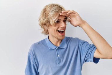 Soyutlanmış arka planda duran genç ve modern bir adam çok mutlu ve gülümsüyor. Çok uzaklara bakıyor. arama kavramı. 