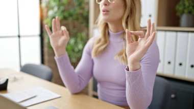 Young beautiful hispanic woman business worker doing yoga exercise at office